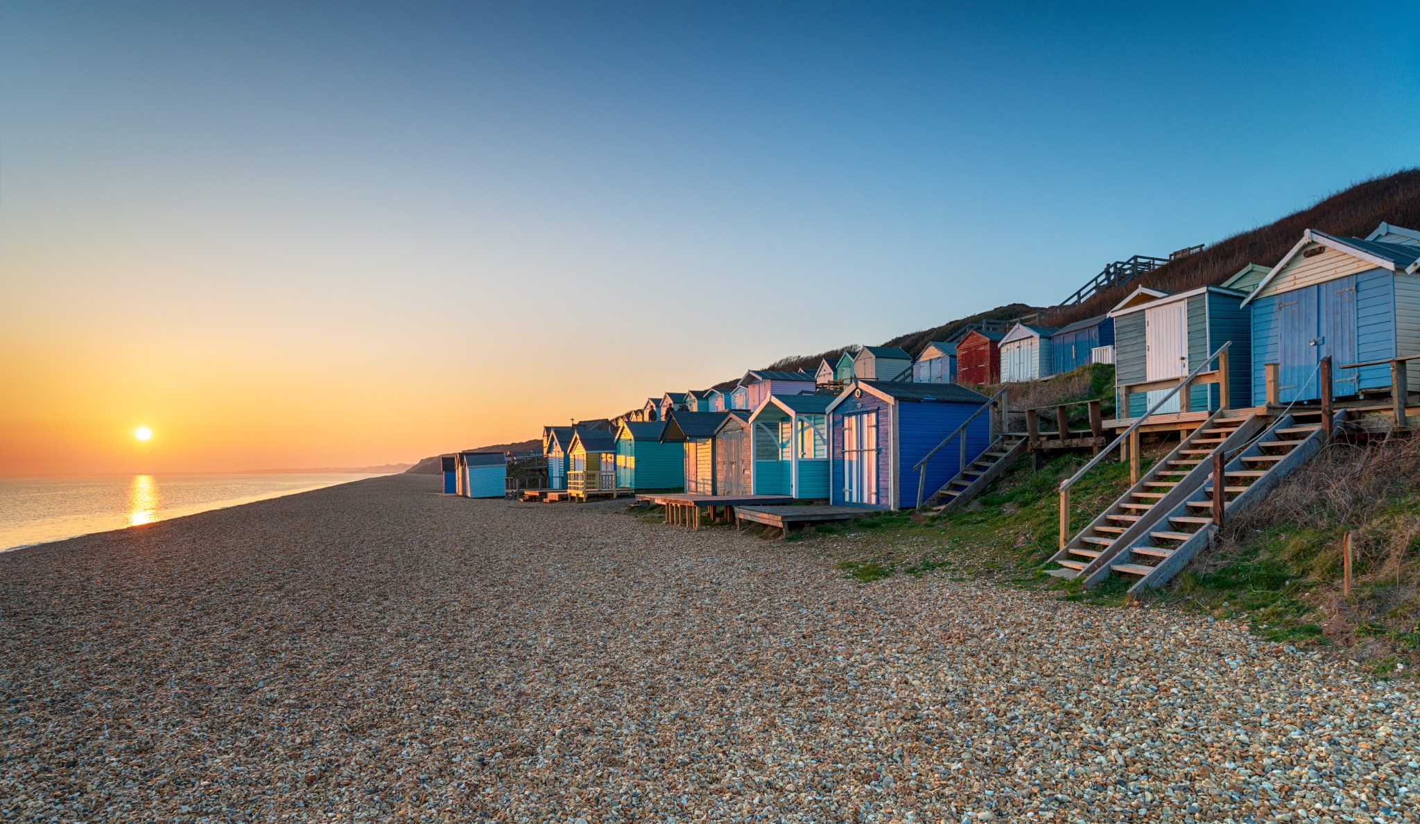 Colourful beach huts on the Sussex coast at sunset